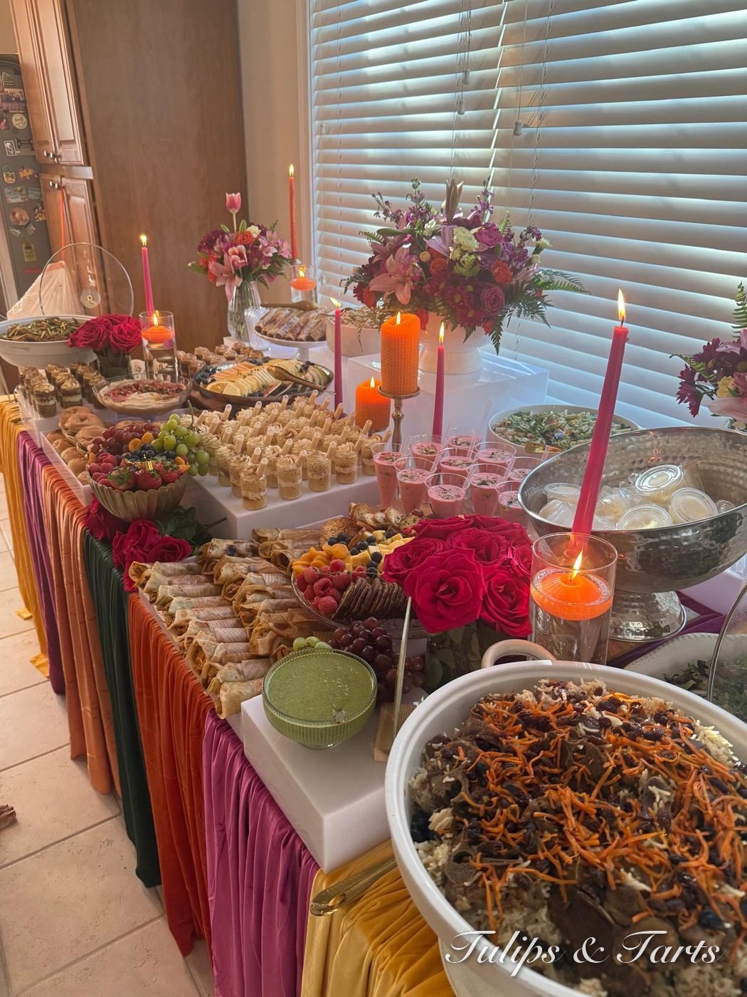 Vibrant halal grazing table with florals, candles and desserts