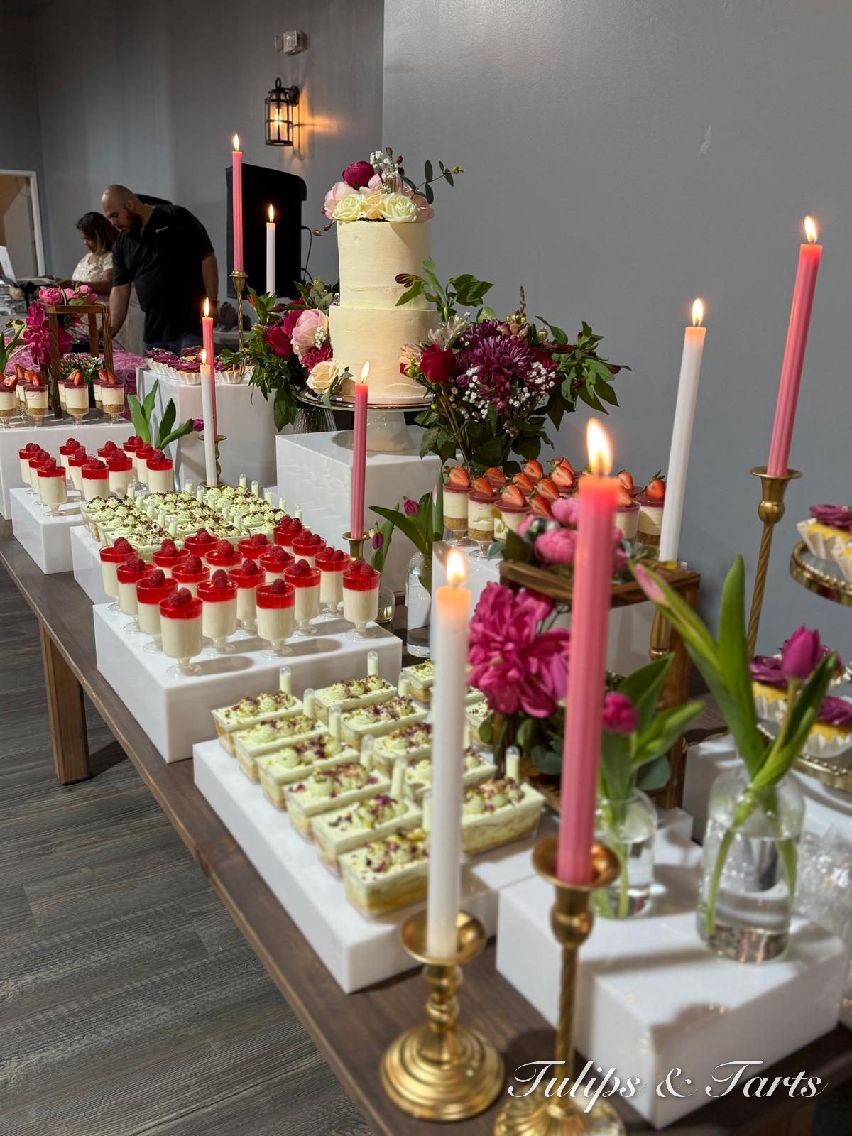 Celebration cake with dessert shooters and pink candles